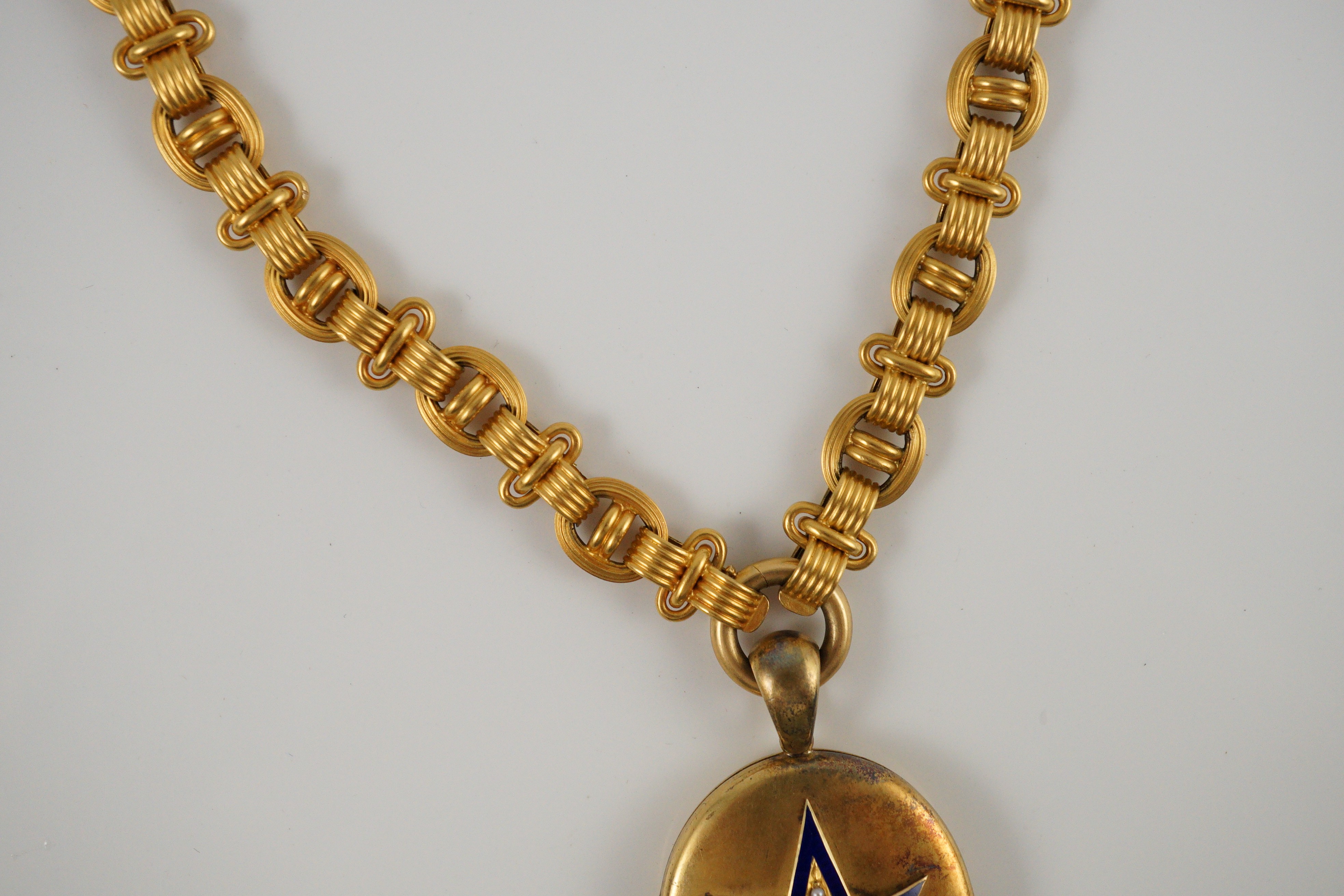 A Victorian gold, enamel and seed pearl set oval locket, on a 19th century Vienna 580/1000 gold chain